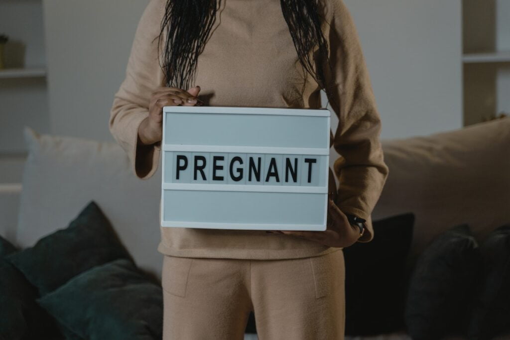https://www.pexels.com/photo/a-woman-holding-a-sign-that-says-pregnant-6463131/